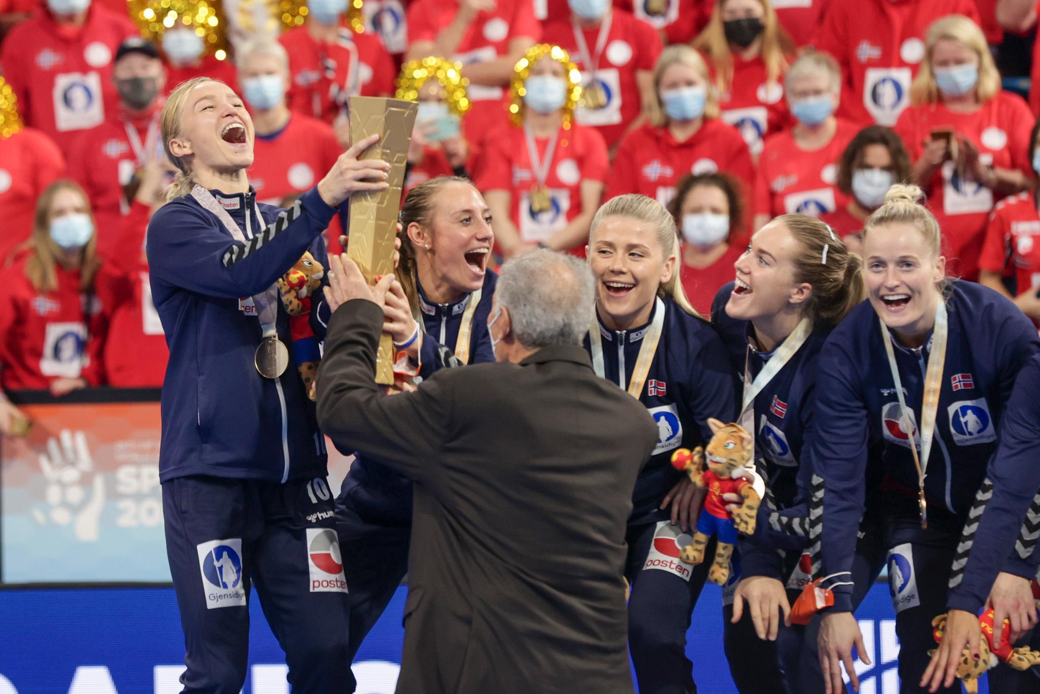 Det internasjonale håndballforbundets president Hassan Moustafa overrekker pokalen til Norges gullvinnere.