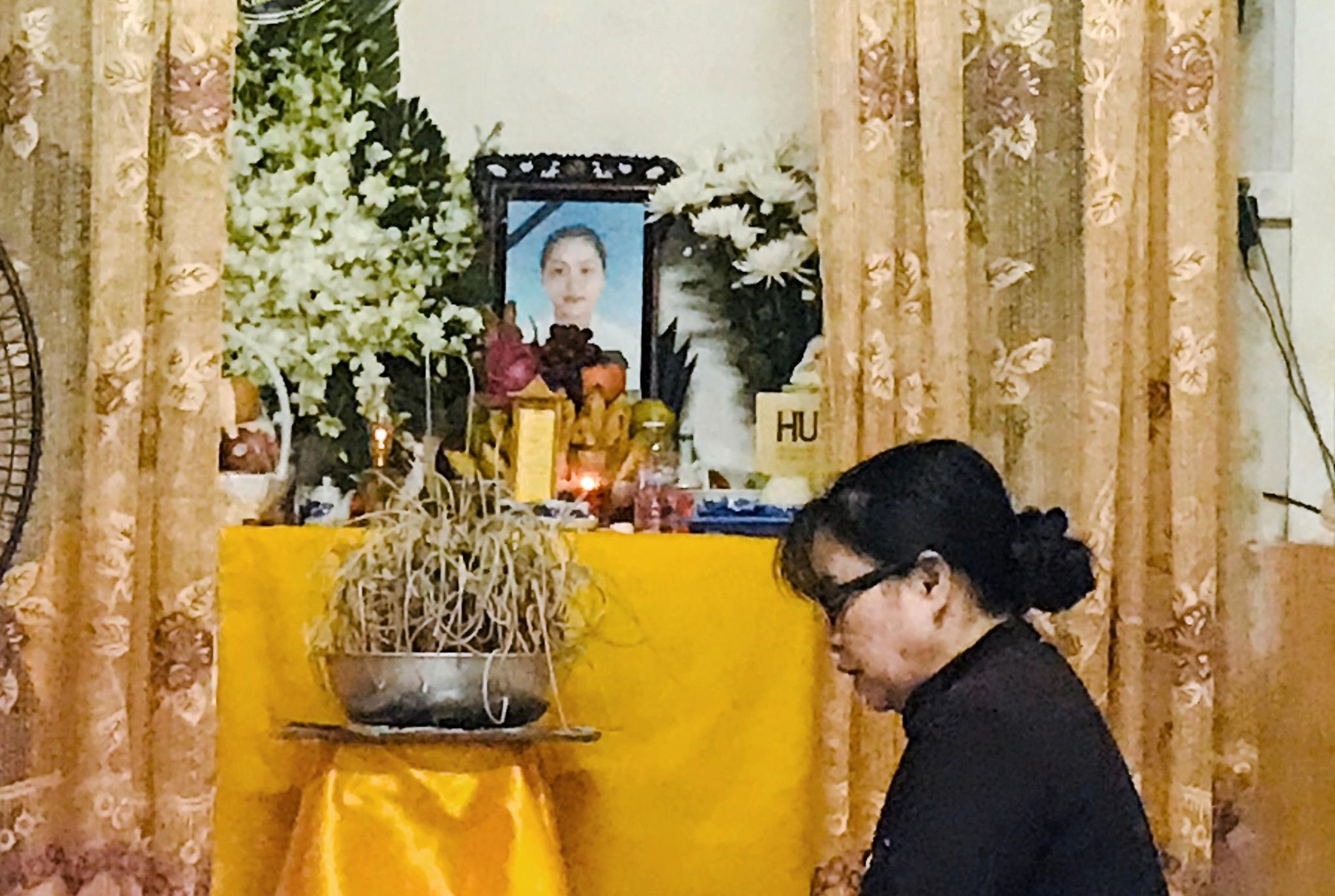En kvinne ber ved et alter med bildet av Pham Thi Tra My (26), som kan ha vært en av de 39 migrantene som ble funnet døde onsdag 23. oktober. 