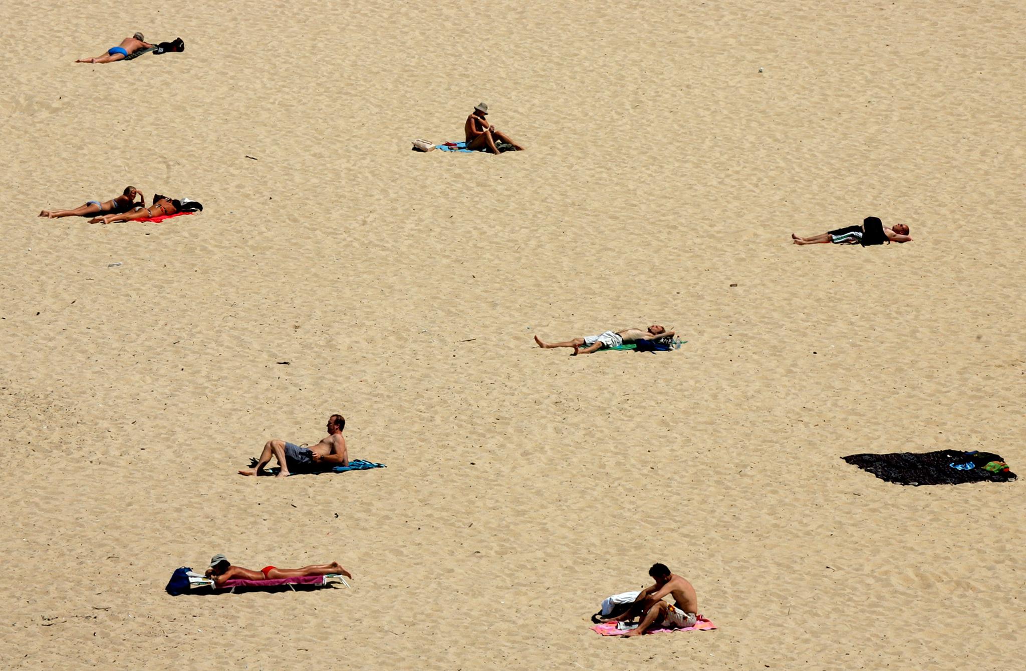 Å ligge på stranden er nettopp det mange nordmenn lengter etter å gjøre i ferien, skriver innleggsforfatterne. Bildet er fra Sydney, Australia.