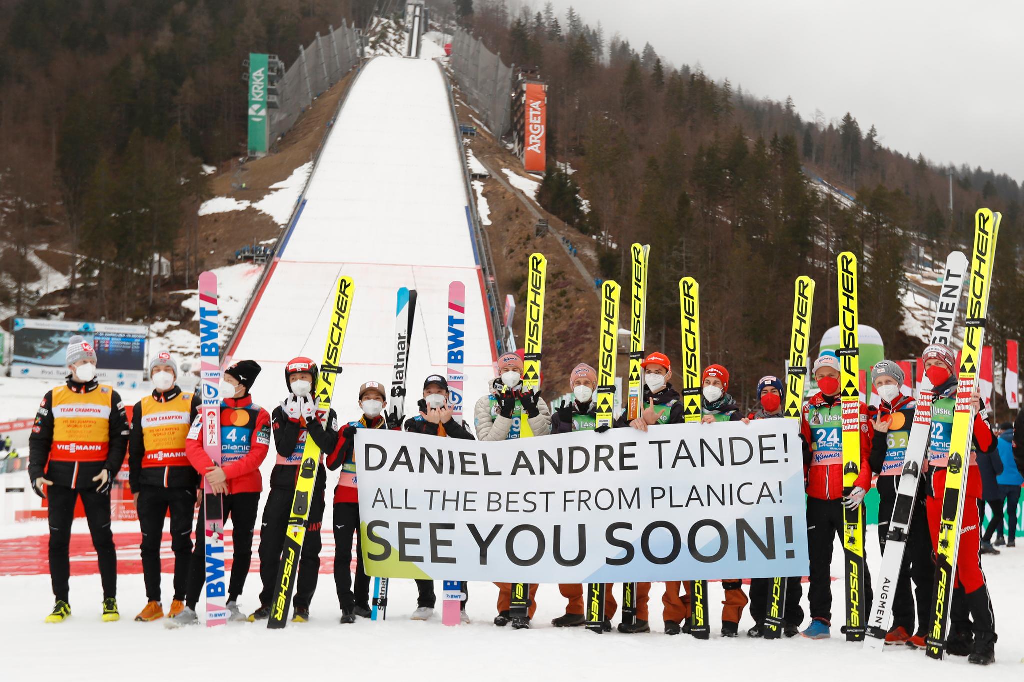 Flere utøvere samlet seg bak et banner og viste Tandes varemerke under verdenscupavslutningen i Planica.