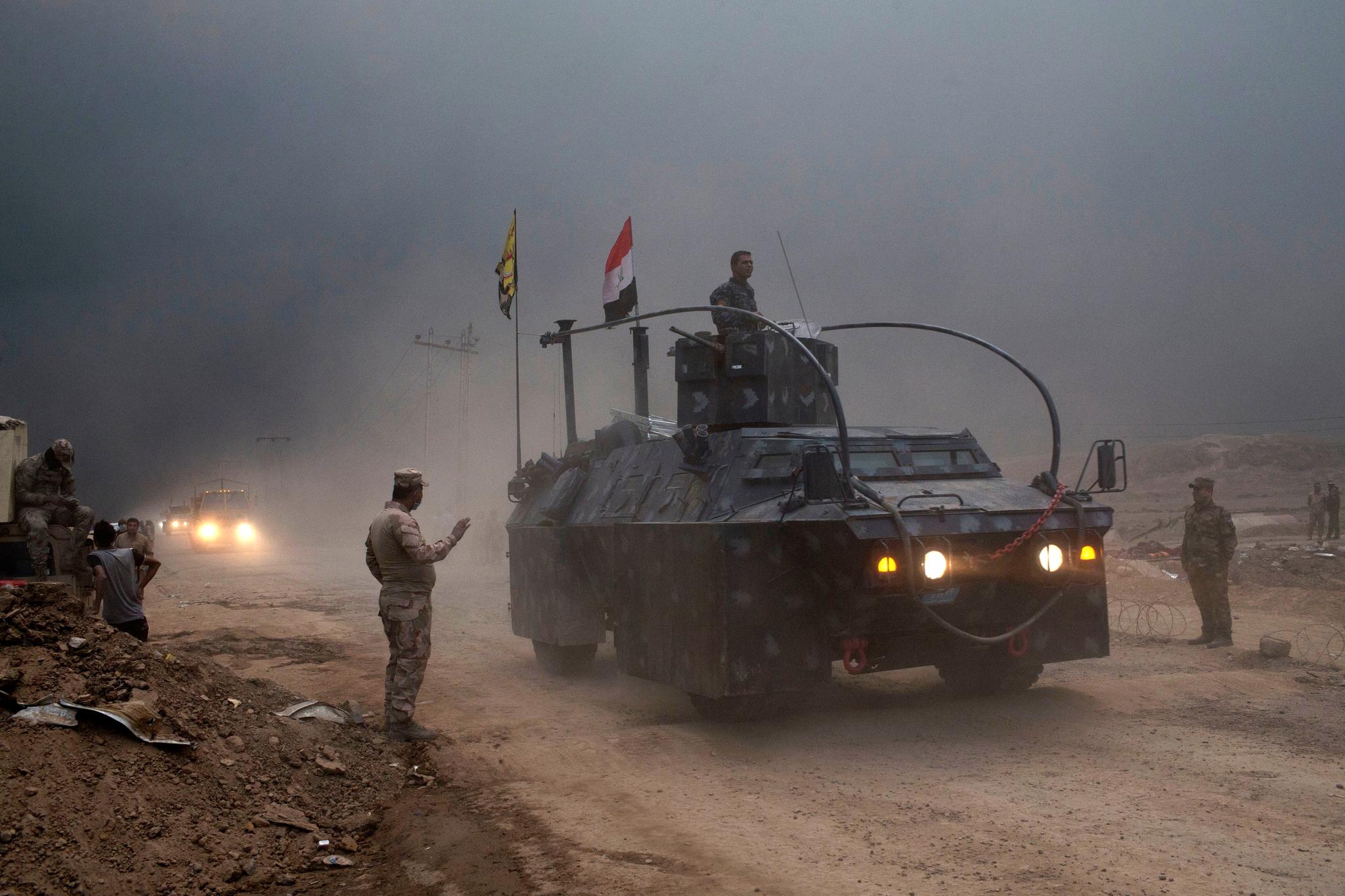 Et pansret kjøretøy tilhørende det føderale irakske politiet passerer en kontrollpost ved Qayara sør for Mosul.