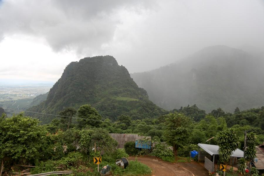 Regnskyer samlet seg over fjellene over grottekomplekset Tham Luang søndag. Etter at første runde med evakuering var fullført kom regnet tilbake.