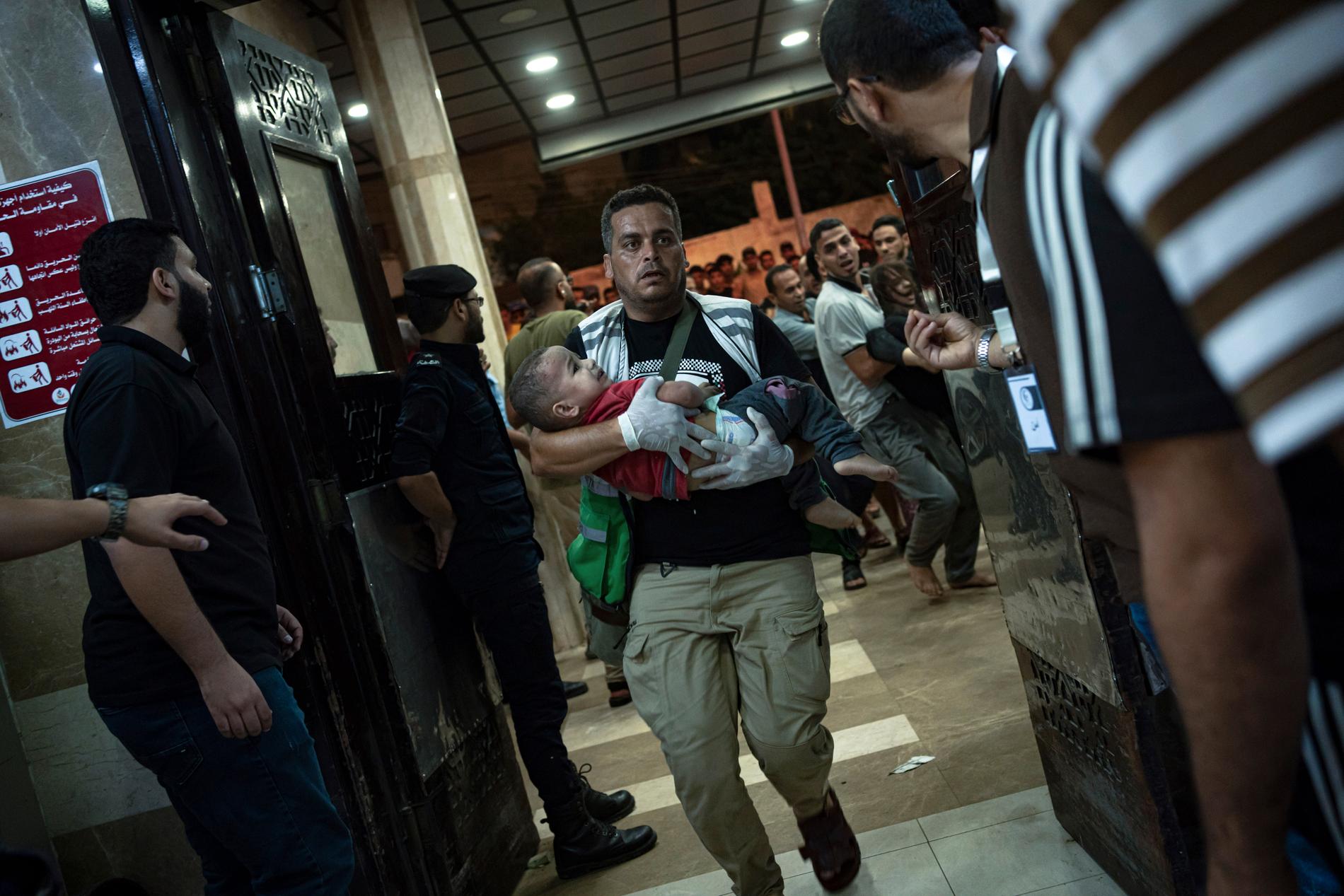 Et såret barn bæres inn i Nasser-sykehuset i Khan Younis sør på Gazastripen etter luftangrep fredag. 