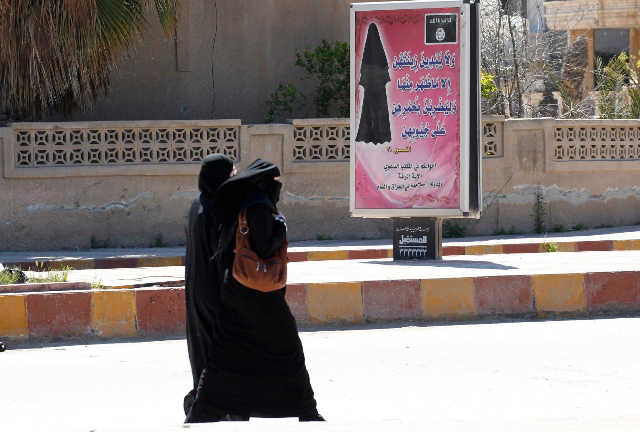 Kvinner som har sluttet seg til IS i Raqqa i Syria møter skilt som påbyr dem å bruke niqab. 