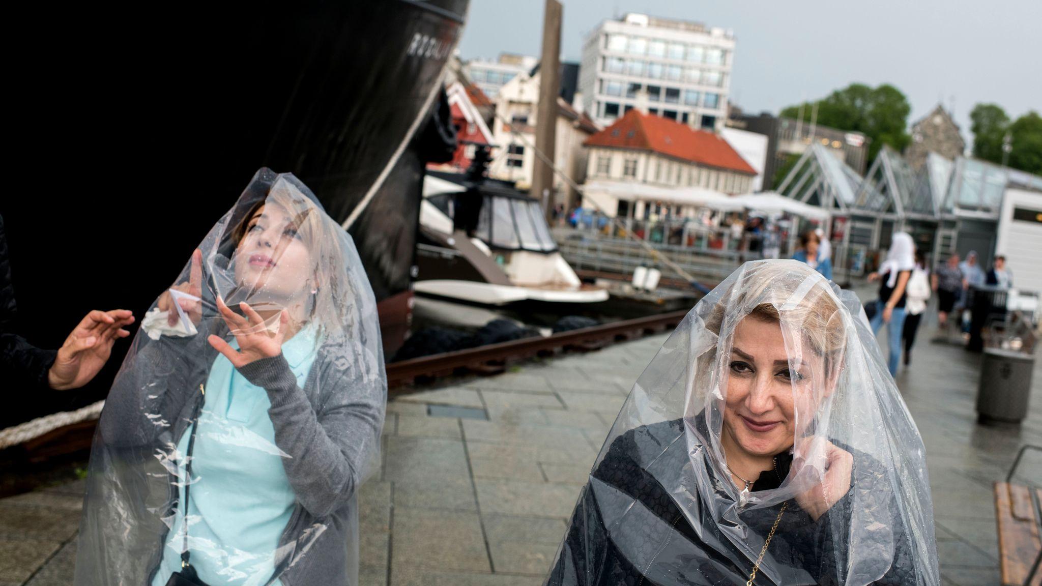 I Stavanger førte styrtregn til salgsboom for regnponchoer. Regnet kom overraskende på cruiseturister.