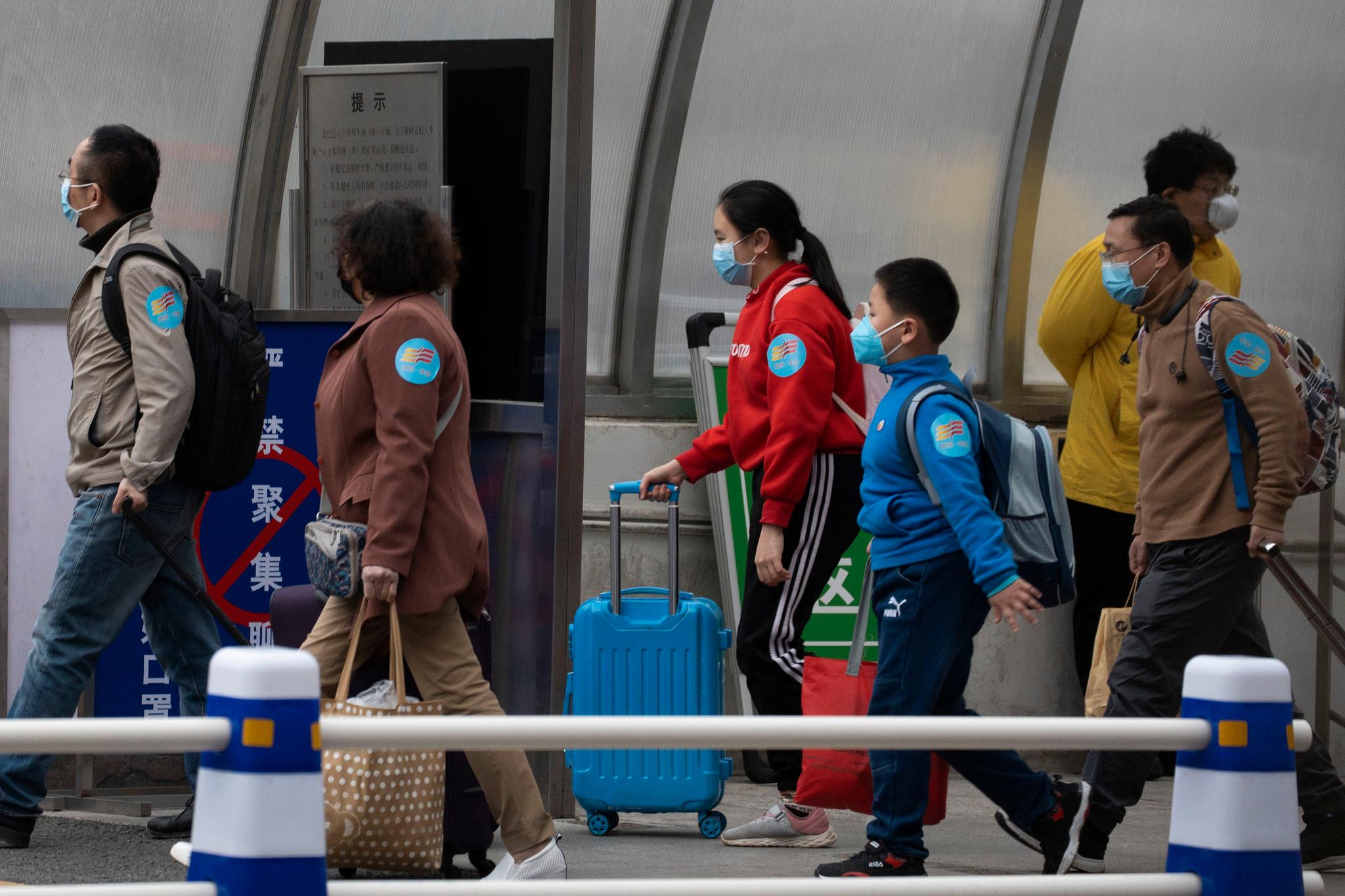 Reisende som har fått lov å forlate Hubei-provinsen etter at de strengeste restriksjonene er opphevet, kommer til jernbanestasjonen i Beijing. 