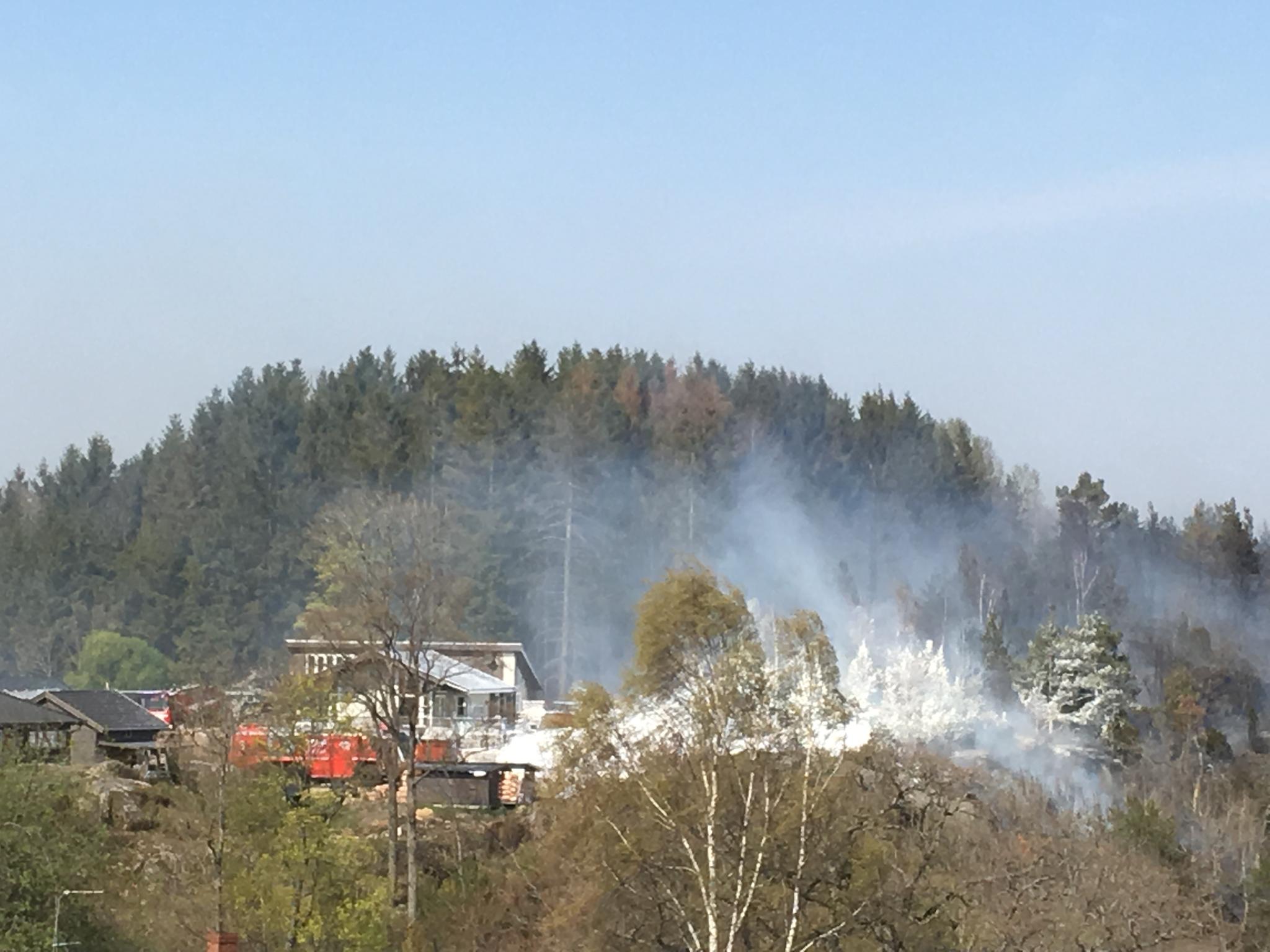 Brannvesenet har ved 13.45-tiden skumlagt et hus for å hindre at skog- og gressbrannen antenner eneboligen.