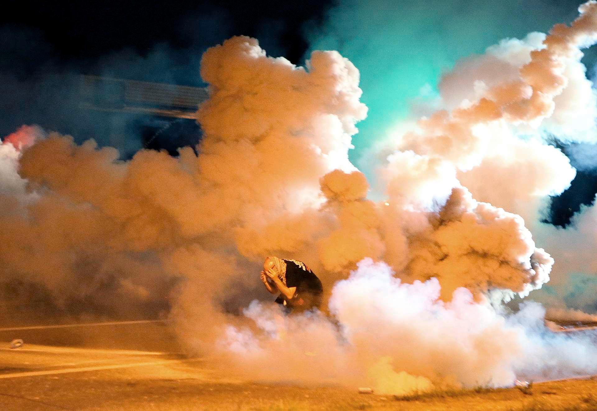 En demonstrant er fanget i tåregassskyer i Ferguson, Missouri.