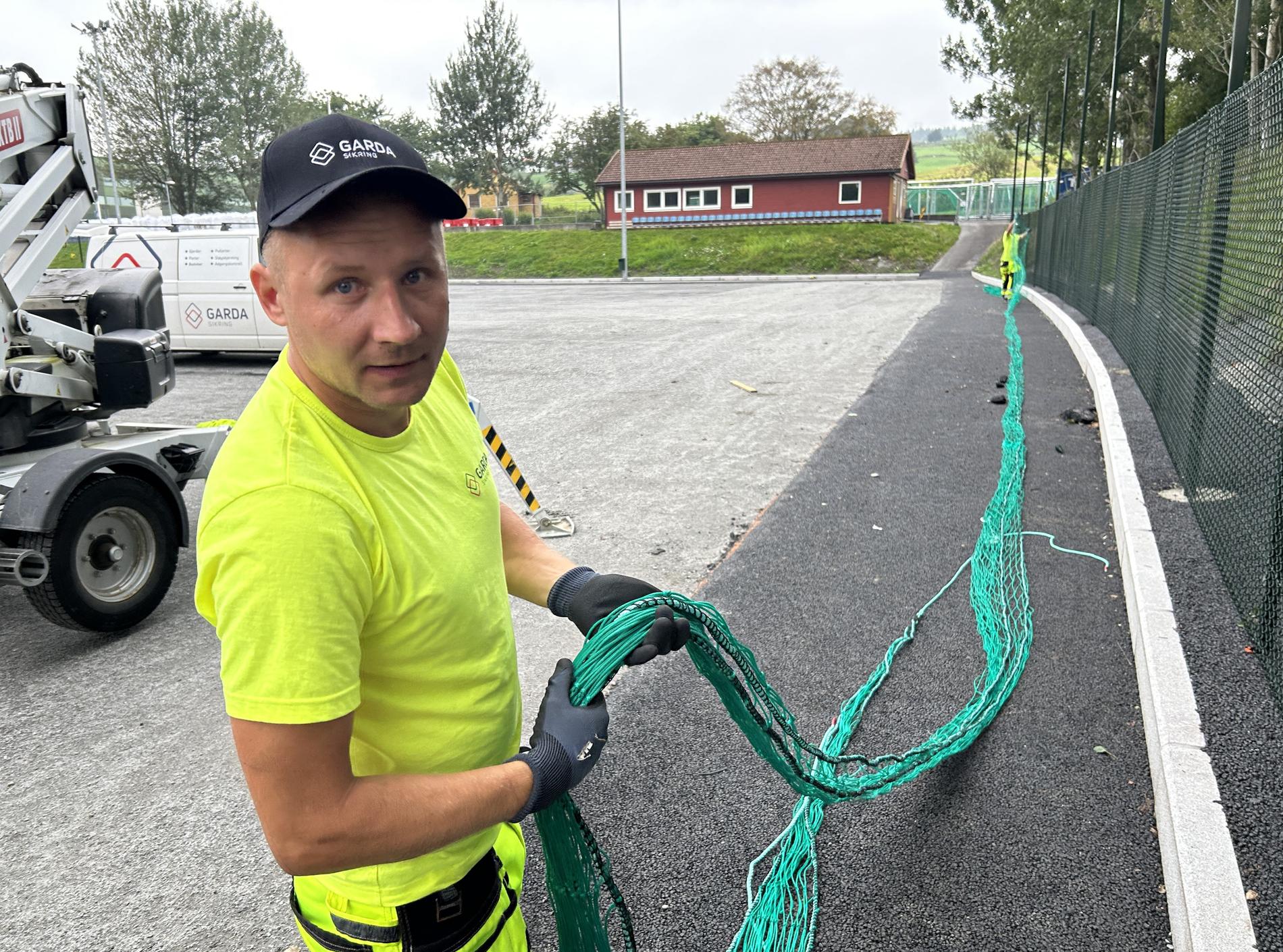 Vytautas Vaitilhvicius i Garda monterer ballnett kring banen i Vikevåg.