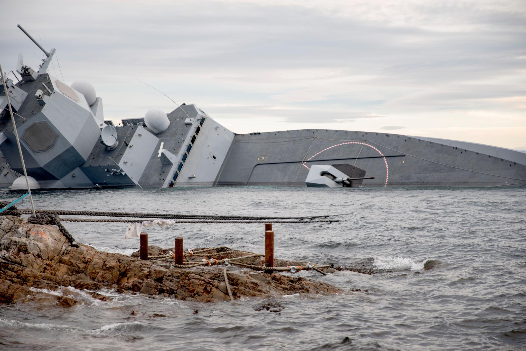 Dette bildet, som er frigitt av Forsvaret, viser hvordan fregatten har lagt seg tungt over på siden. Deler av broen og våpensystemenene ligger nå under vann.