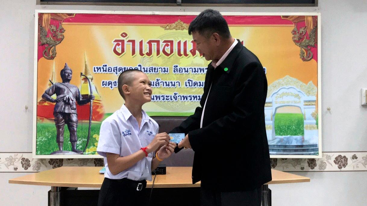 Her får Mongkhol Boonpiam (13) et identitetskort som bekrefter hans thailandske statsborgerskap. Foto: AP / NTB scanpix