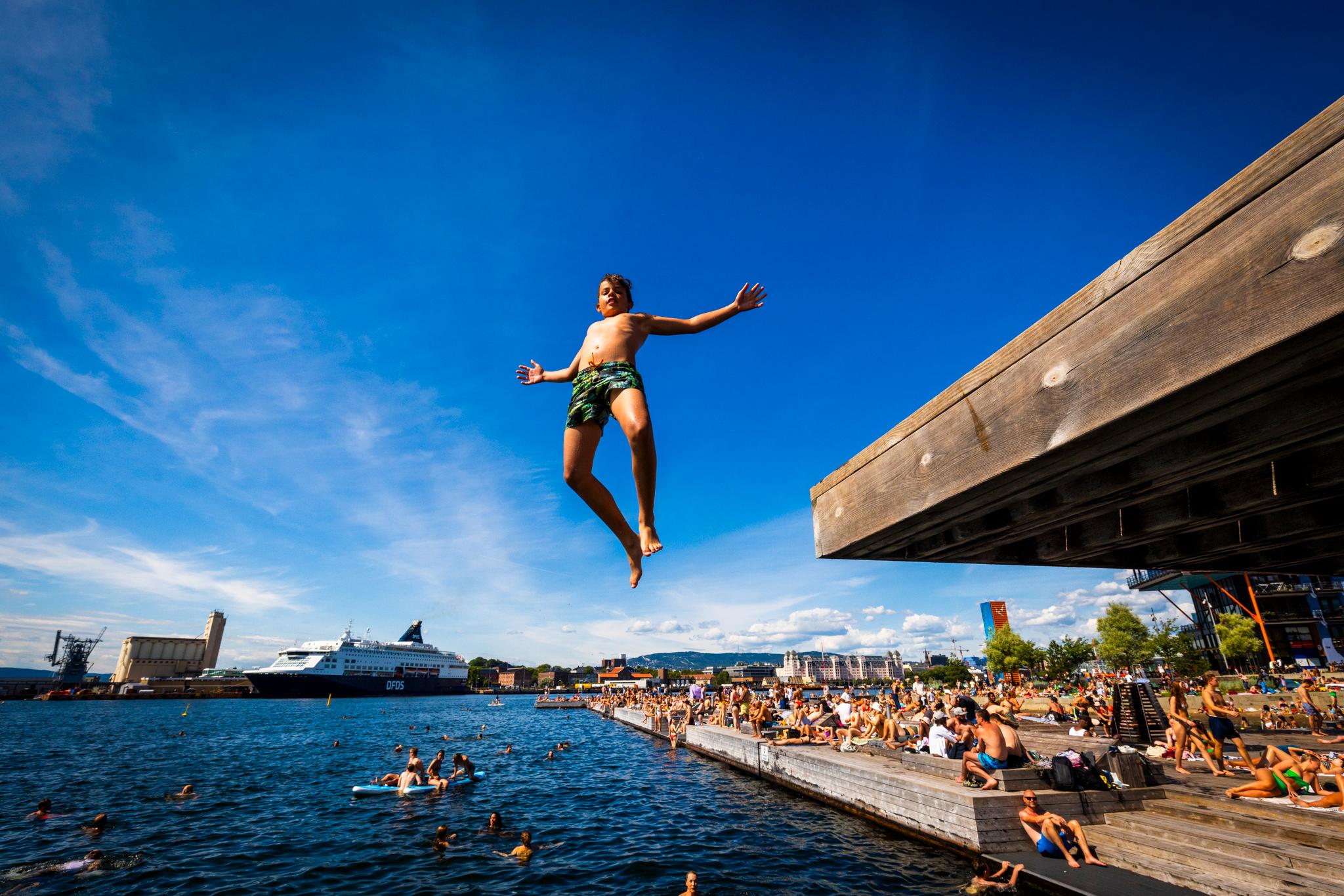 Agustin Merno Aarsæther hopper ut i vannet fra et stupebrett på Sørenga i Oslo. 