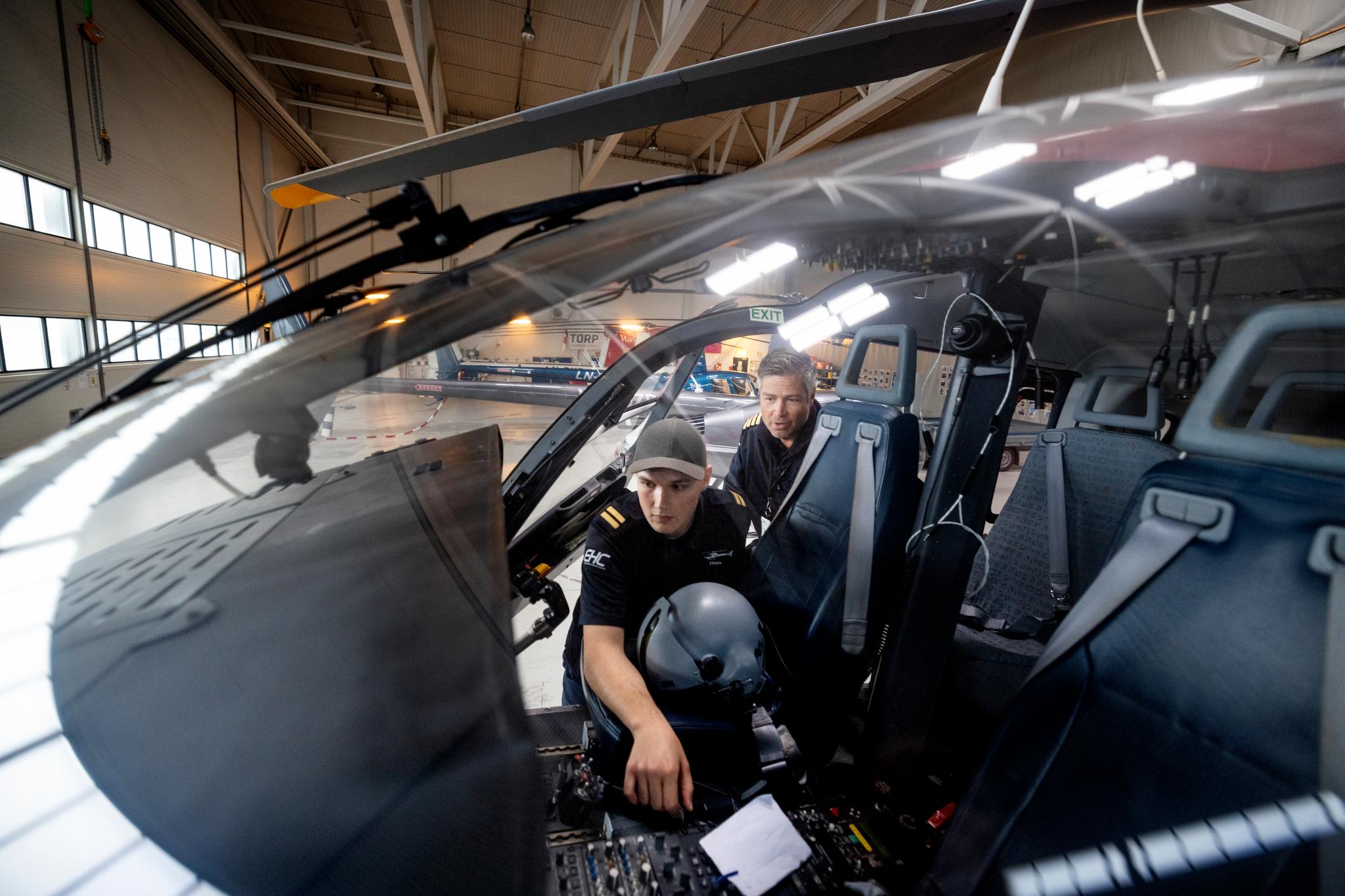 Preben Eken Nygård vil på slutten av sin utdannelse på Torp få føre tomotorshelikopter som han skal fly via instrumenter. Foreløpig slipper han bare til ved spakene på et énmotorshelikopter som han flyr visuelt. Bak: Skolesjef Peter Blom. 