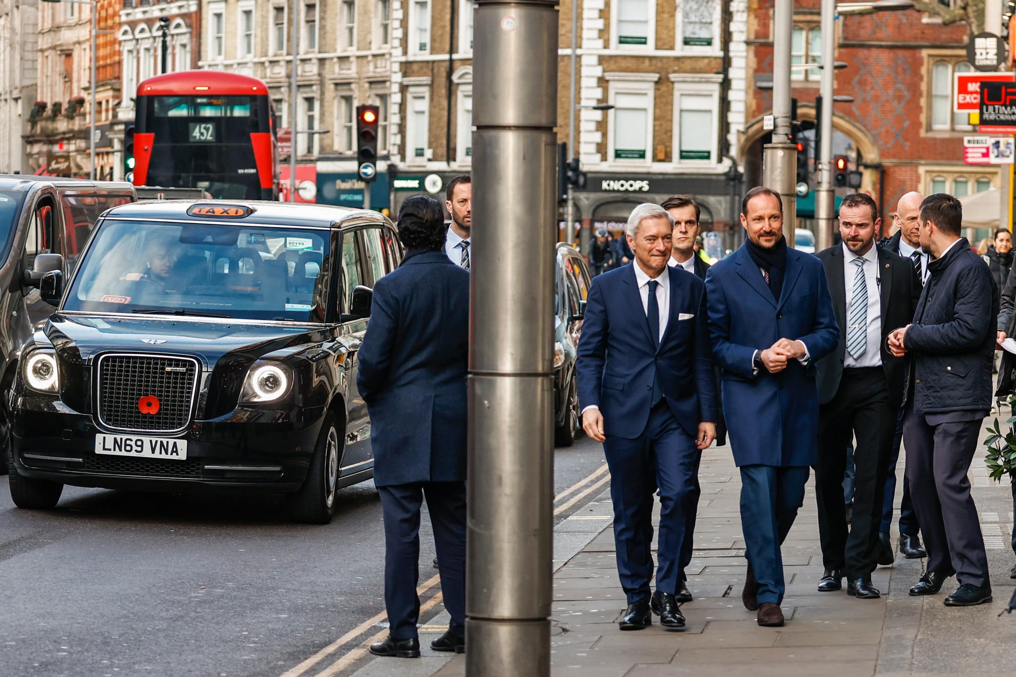 Kronprins Haakon og den norske ambassadøren i Storbritannia,  Wegger Chr. Strømmen, ankommer Royal Garden Hotel til fots i London onsdag morgen. 