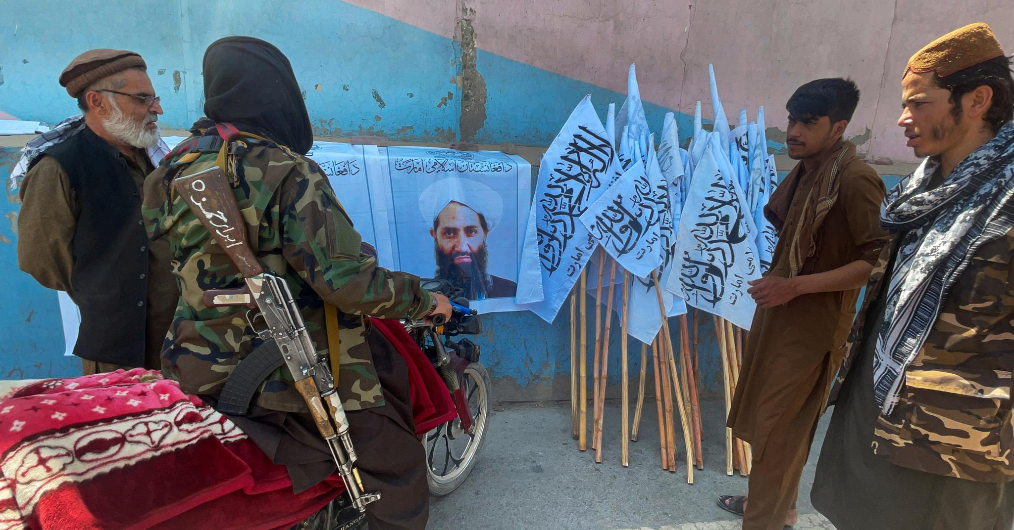 Taliban-soldater i Kabul står samlet rundt det eneste kjente bildet av gruppens øverste leder, Haibatullah Akhundzada.