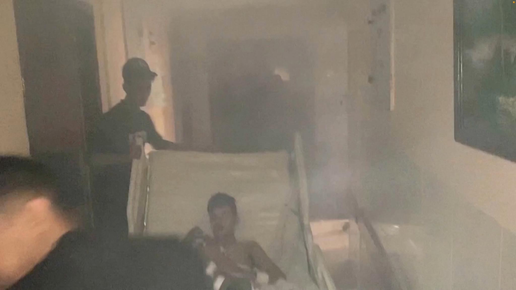 A photo allegedly taken from inside Al-Shifa Hospital during the Israeli military raid on Wednesday.  The patient is transported through a smoke-filled corridor into the hospital. 