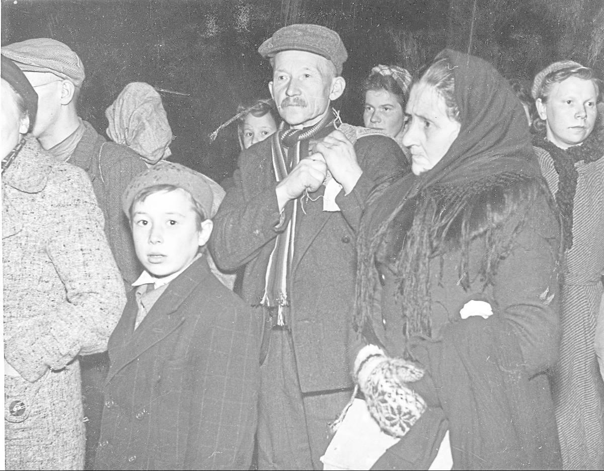 Ansiktene til unge som gamle bærer preg av stundens alvor etter flukt fra Norge til Sverige under krigen.