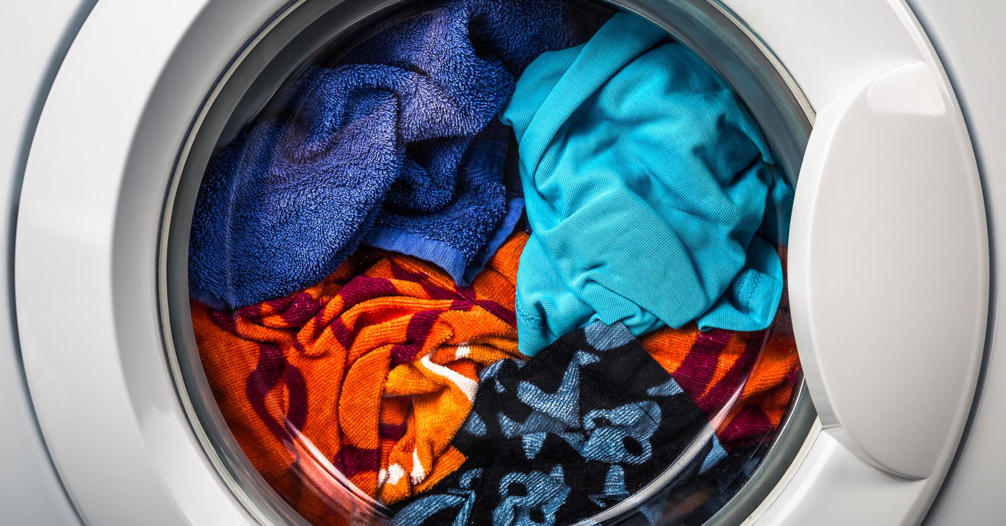 Мытье одежды. Стиральная машина с бельем. Цветные вещи в стиральной машине. Стиральная машинка с вещами. Стирка в машинке.