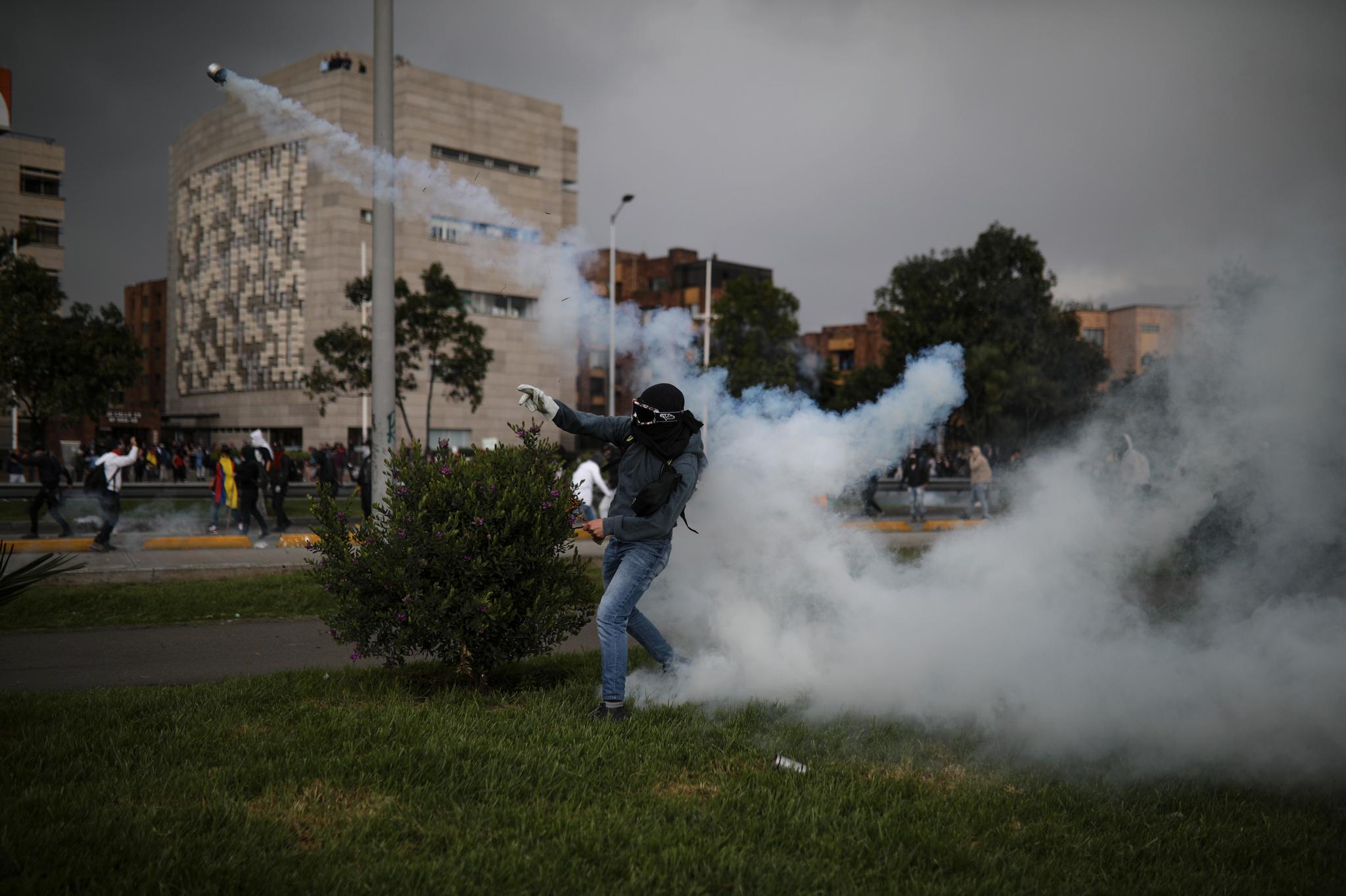 Demonstranter kaster tåregassbeholdere tilbake mot politiet i Bogota i Colombia torsdag. Fredag fortsatte protestene i landet. 