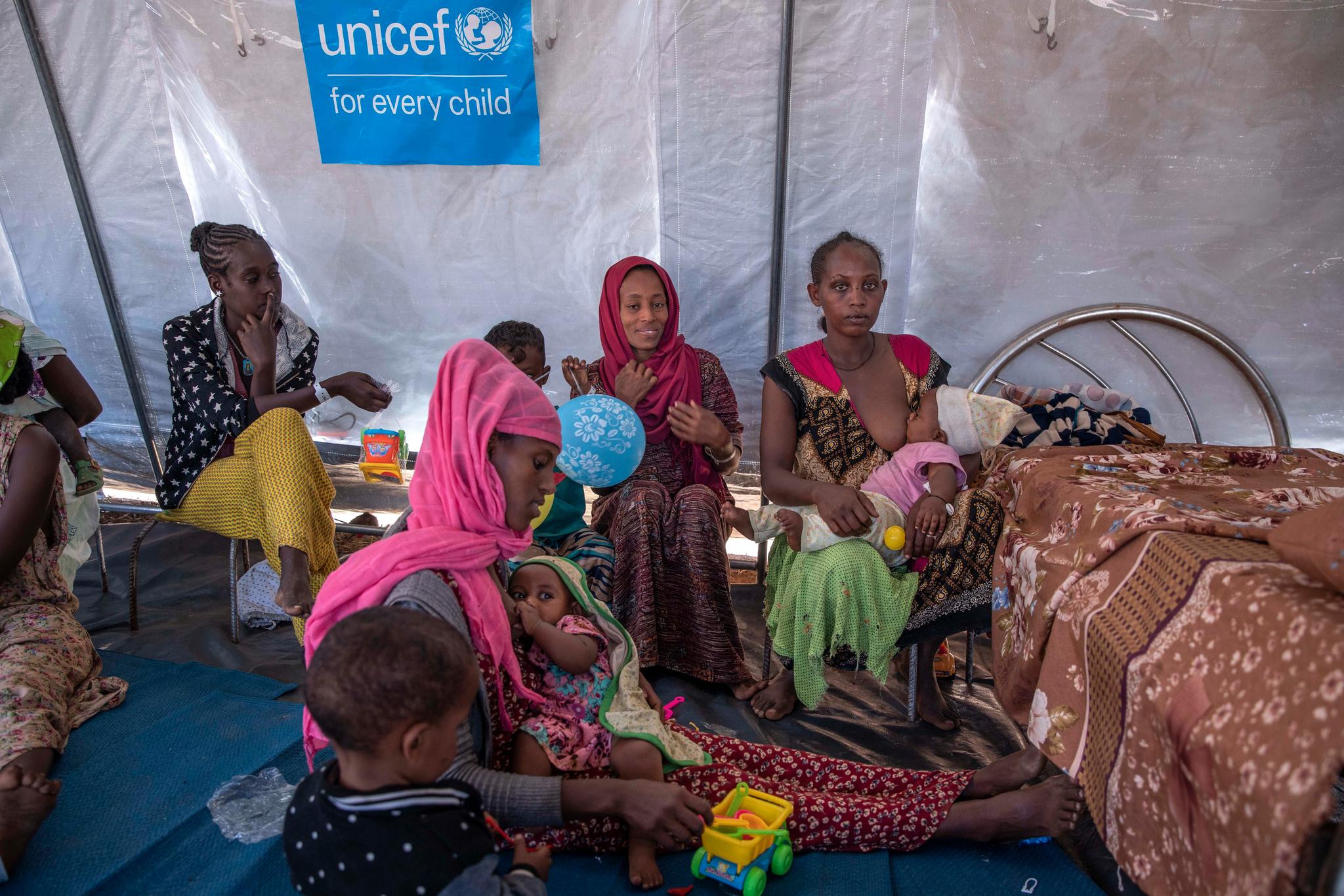 En gruppe kvinner og barn som har lykkes i å flykte fra Tigray, sitter sammen i Umm Rakouba-leiren i Sudan. 