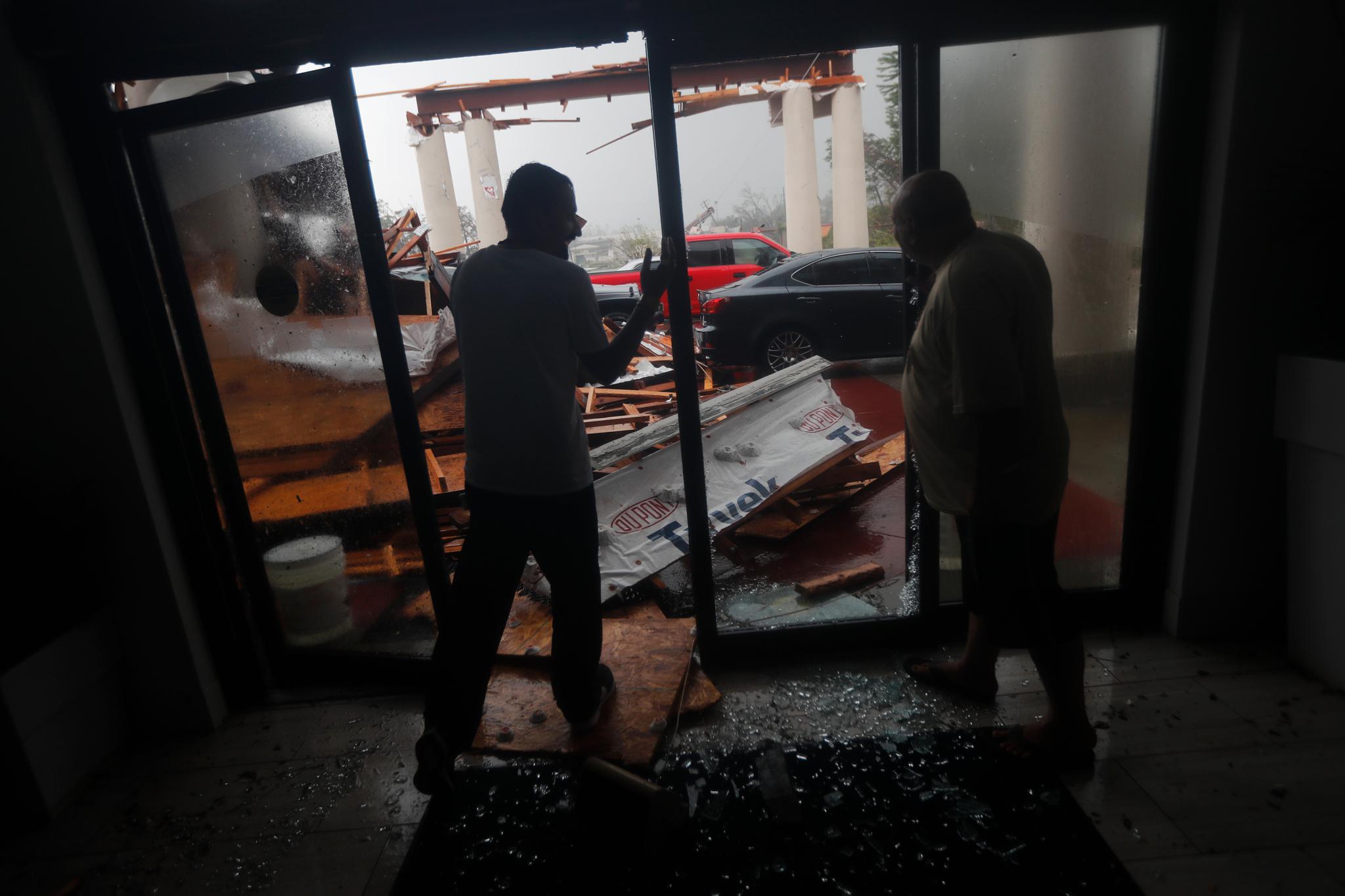 Hotellansatte ser på ødeleggelsene orkanen Michael har forårsaket i Panama Beach City. 