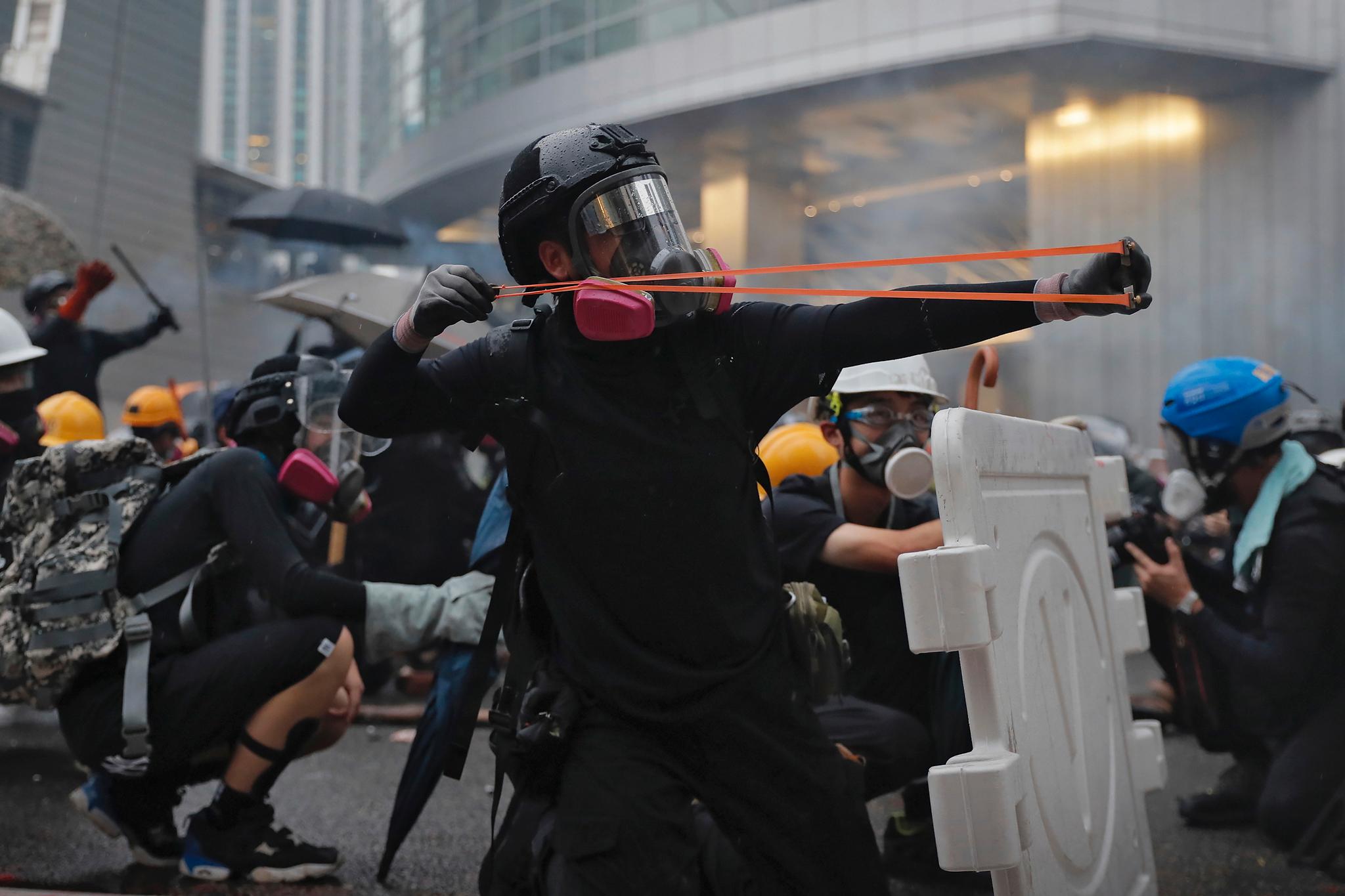 En demonstrant skyter med sprettert på politiet.