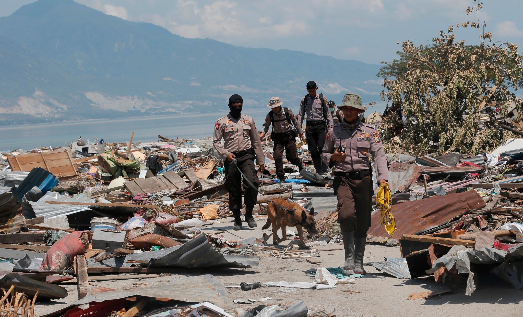  En politienhet fortsetter å søke etter ofre i ruinene etter jordskjelvet og tsunamien. Nødhjelpen kommer sakte inn til områdene som er ødelagt av jordskjelvet. 