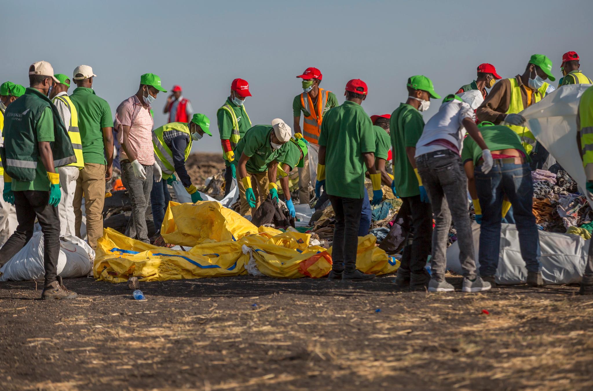 Mannskaper samler klær og andre gjenstander på ulykkesstedet i Etiopia.