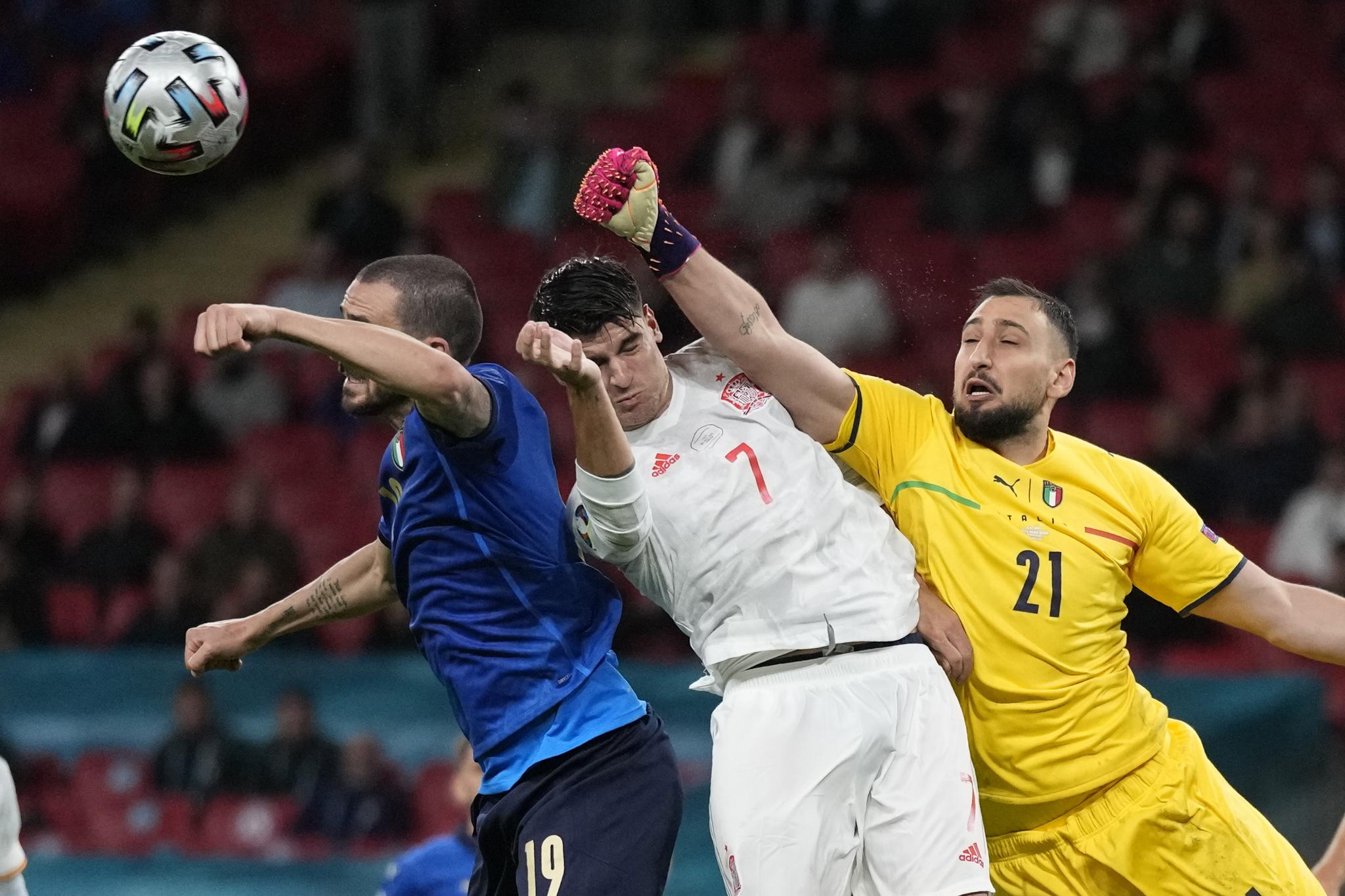 Italias målvakt Gianluigi Donnarumma hiver seg inn i en duell i semifinalen mot Spania.
