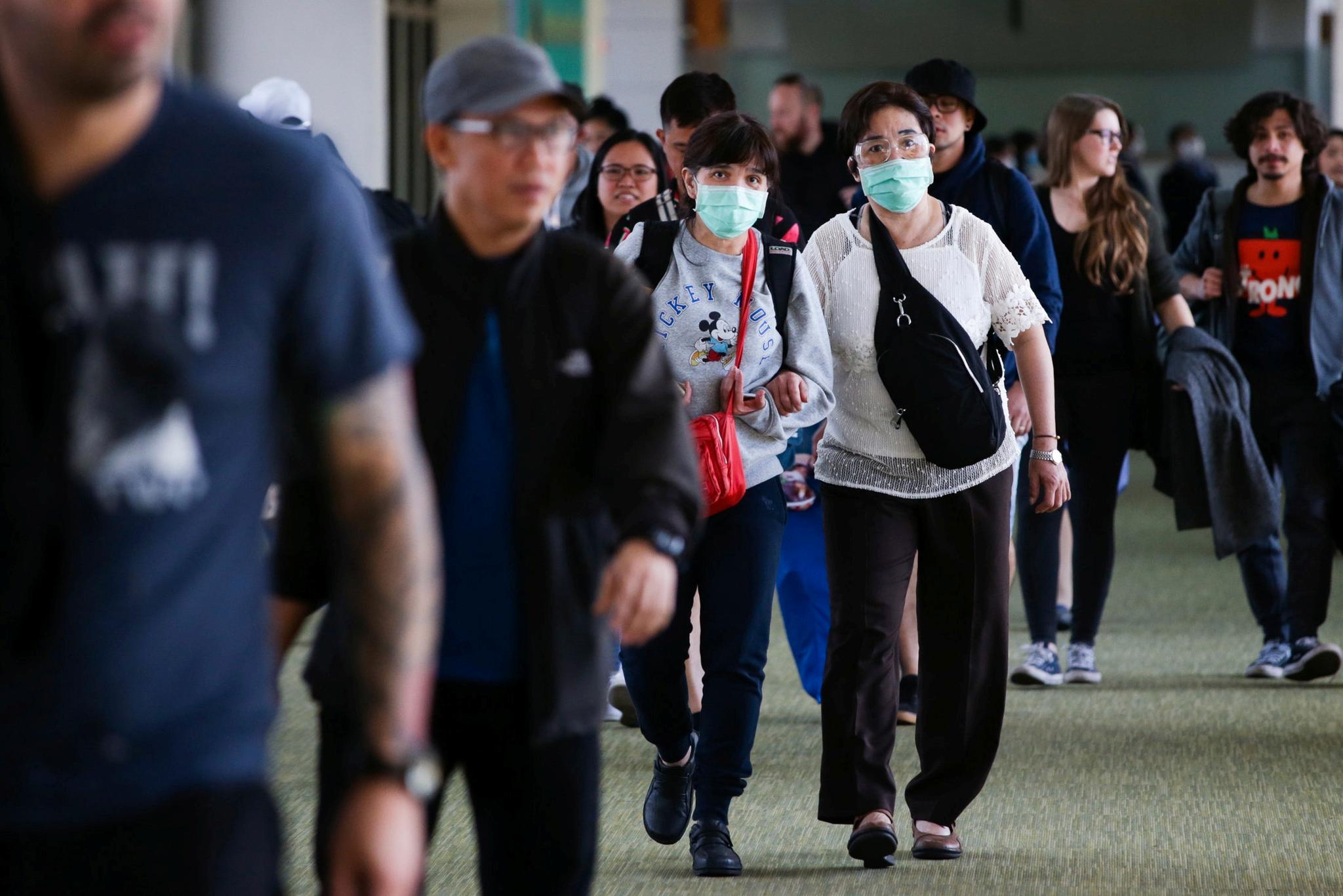 Passaskjerer på etfly fra Taiwan bærer munnbind ved ankomst Ninoy Aquino-flyplassen på Filippinene. 