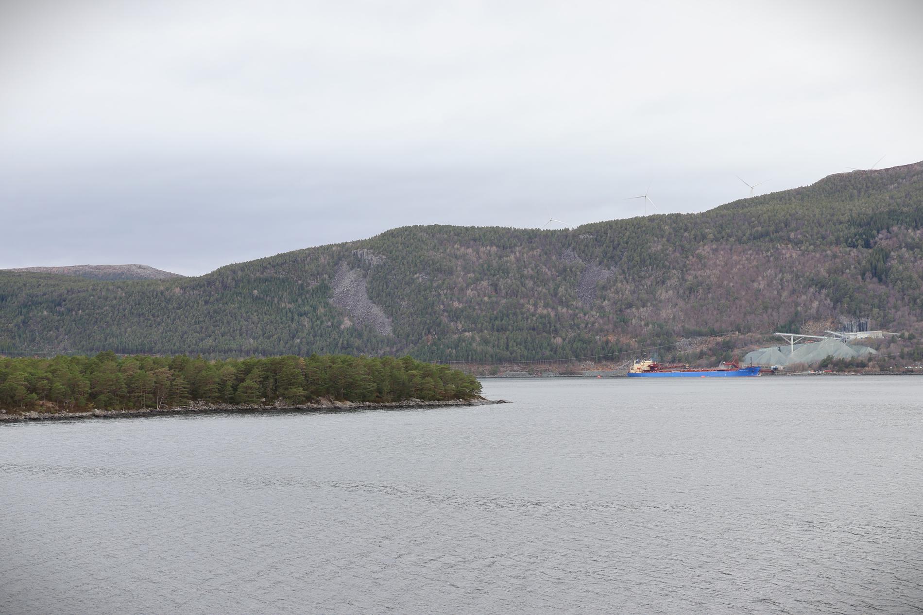 Til venstre på bildet ligger Holmaneset, der Fortescue planlegger sin hydrogen- og ammoniakkfabrikk. Til høyre ligger steinbruddet Bremanger Quarry, og over fjellet skimtes vindkraftverket Hennøy.