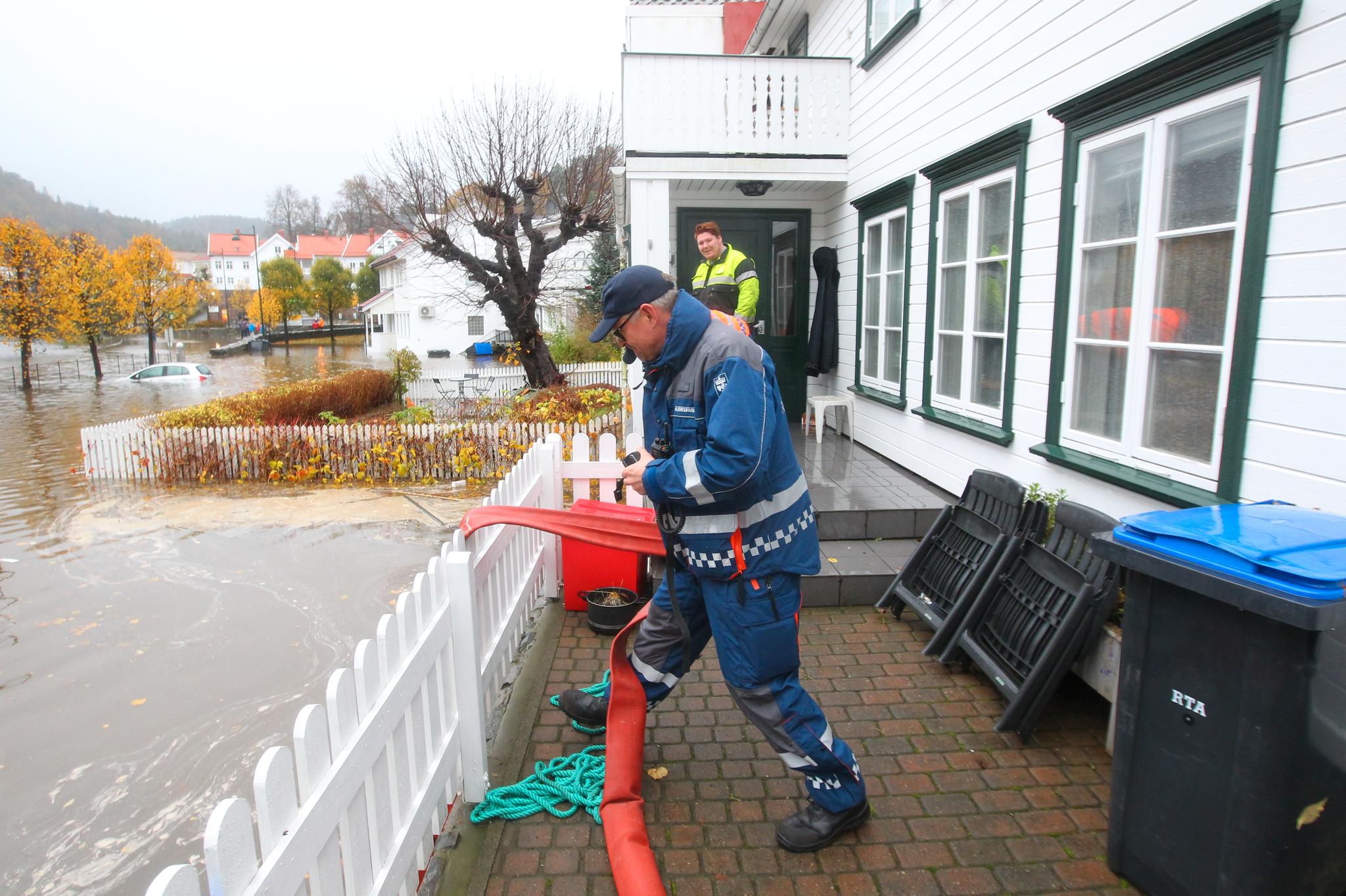 Mannskap fra Sivilforsvaret hjelper til med å lense vann fra en kjeller i Tvedestrand. Regnet øste ned på Sørlandet i helgen og forvandlet veier, parkeringsplasser og folks hager til svømmebasseng. Flere steder ble TV-aksjonen avlyst.