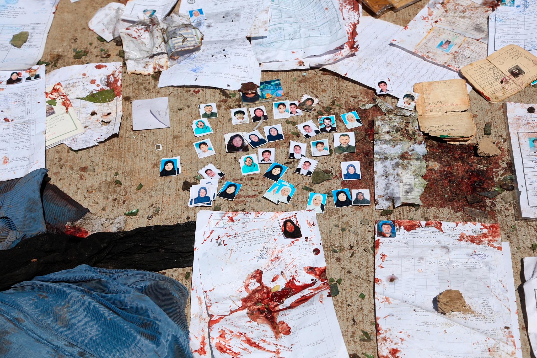 Bilder og ID-papirer med blod ligger igjen på bakken etter angrepet.
