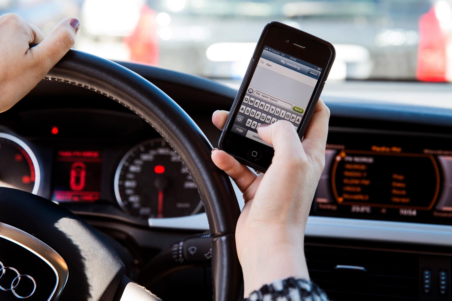 Reglene for bruk av mobiltelefon i bil har blitt innskjerpet. Illustrasjonsfoto