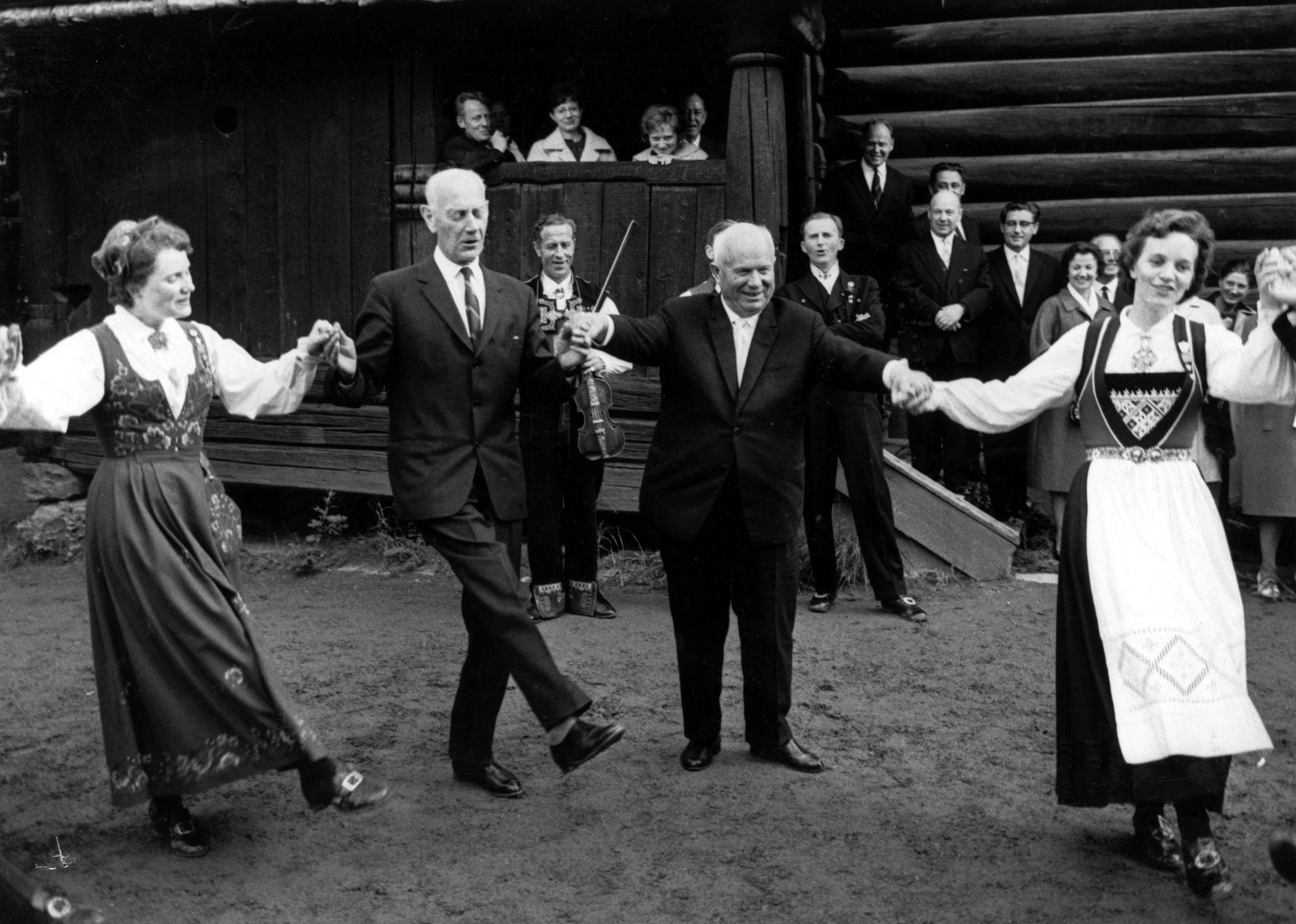 Sovjets leder Nikita Khrustsjov (til høyre) lærer å danse norsk folkedans under et statsbesøk i 1964 på Norsk Folkemuseum på Bygdøy i Oslo. Her danser han sammen med Einar Gerhardsen.