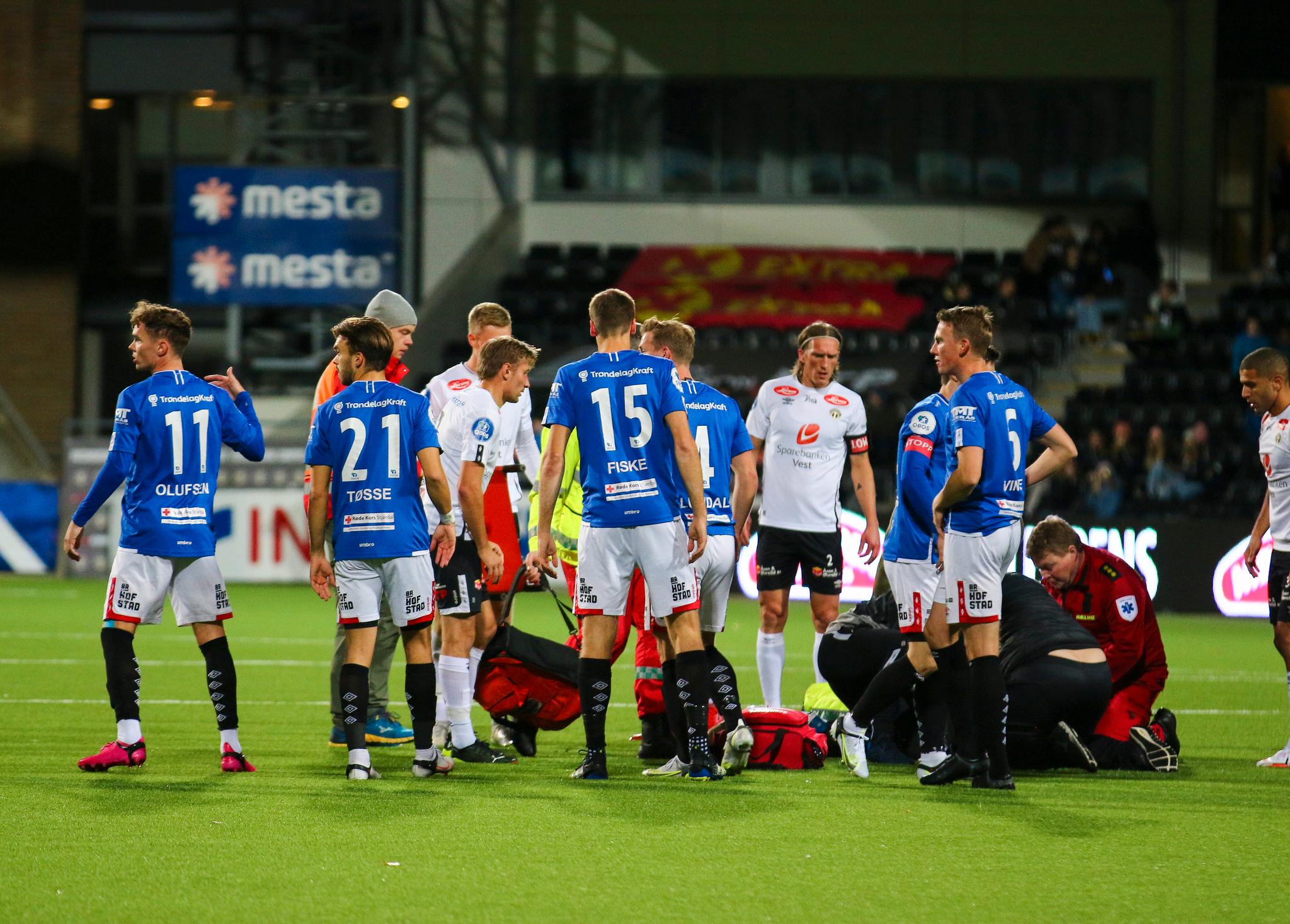 DRAMATISKE BILDER: Emil Pálsson får behandling på banen av helsepersonell, mens spillere står rundt. 