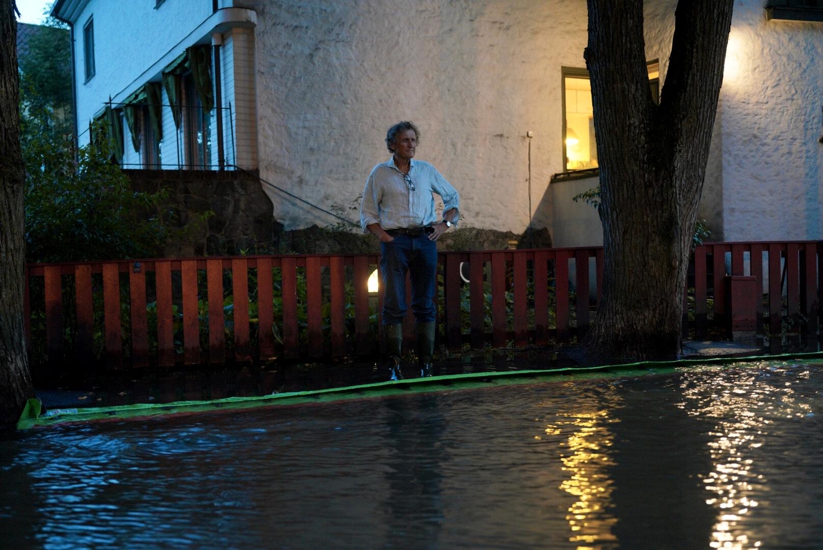 Jo Piene kikker ut på oversvømmelsen i gaten der han bor. 